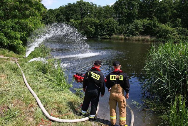 Feuerwehrleute pumpen Sauerstoff in de...l, um das Algenwachstum zu verhindern.  | Foto: Krzysztof Swiderski (dpa)