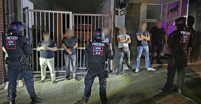 Polizisten bewachen in Essen am Samstag Tatverdchtige.  | Foto: Markus Gayk (dpa)