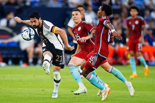 Szene mit Seltenheitswert: Der deutsch...und Juan Cuadrado (r.) zum Torschuss.   | Foto: Rolf Vennenbernd (dpa)