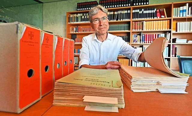 Christoph Schmider mit den archivierten Berichten aus den Pfarreien  | Foto: Michael Bamberger