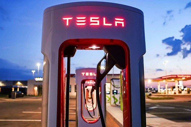 Eine Ladesule von Tesla steht an einem Autohof im Morgenlicht.  | Foto: Jan Woitas (dpa)