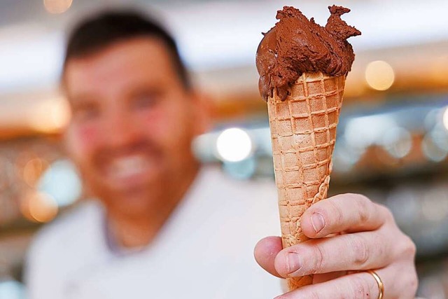 Der Eismacher Luca de Rocco hlt in se...el veganem Schokoladeneis in der Hand.  | Foto: Daniel Karmann (dpa)