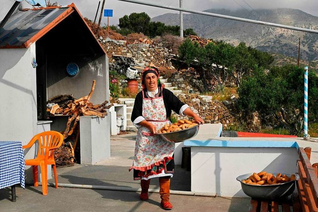 Die Bckerin Irini Chatzipapa trgt fr...gebackenes Gebck aus ihrer Backstube.  | Foto: LOUISA GOULIAMAKI (AFP)