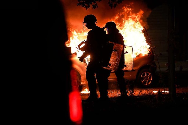Straburg: Bereitschaftspolizisten ste...brennenden Autos im Viertel La Meinau.  | Foto: Jean-Francois Badias (dpa)