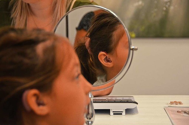 Rosa mit Glitzer: Njunja betrachtet ihre neuen Hrgerte im Spiegel.   | Foto: Felix Lieschke-Salunkhe