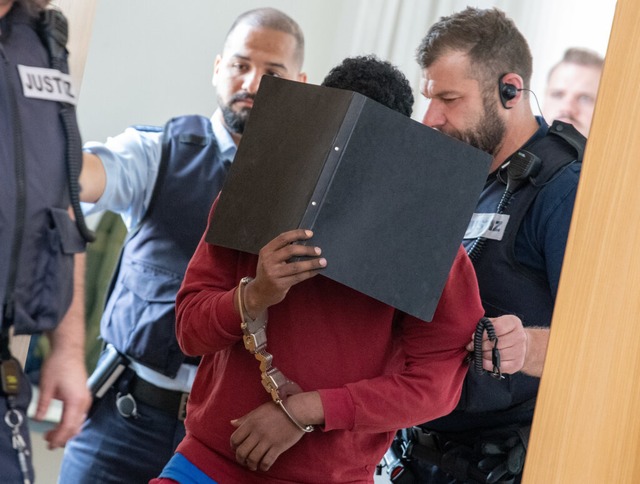 Der Tter verdeckt im Gericht sein Gesicht hinter einem Ordner.  | Foto: Stefan Puchner (dpa)