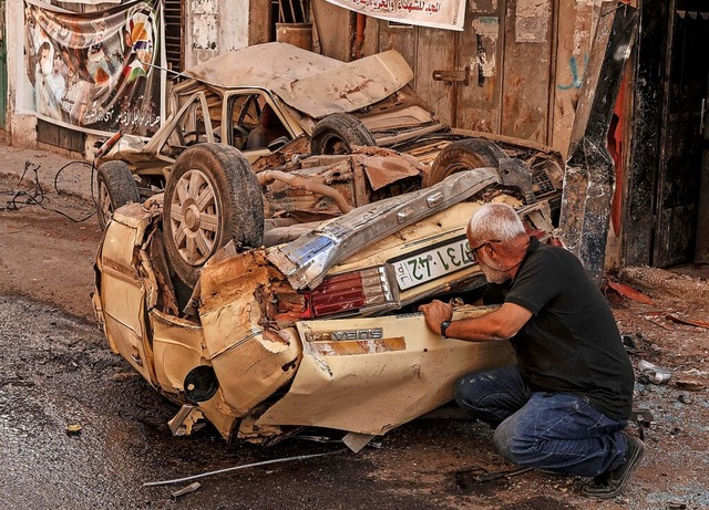 Ein Mann an einem beim Einsatz der Israelis zerstrten Auto  | Foto: RONALDO SCHEMIDT (AFP)