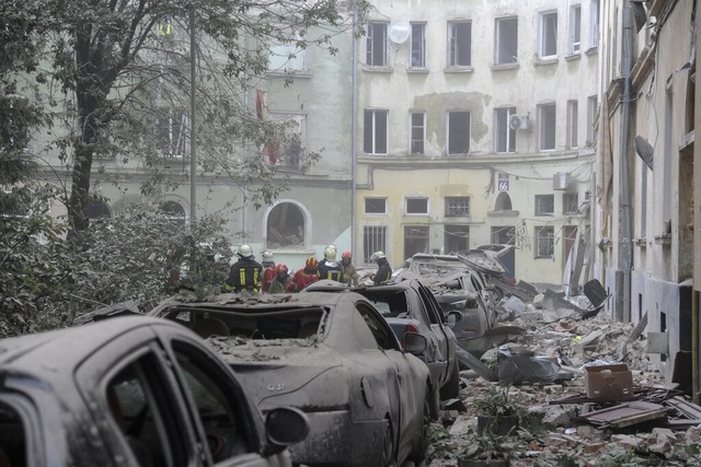 Rettungskrfte versammeln sich vor bes... nach einem Raketenangriff weitergeht.  | Foto: Mykola Tys (dpa)