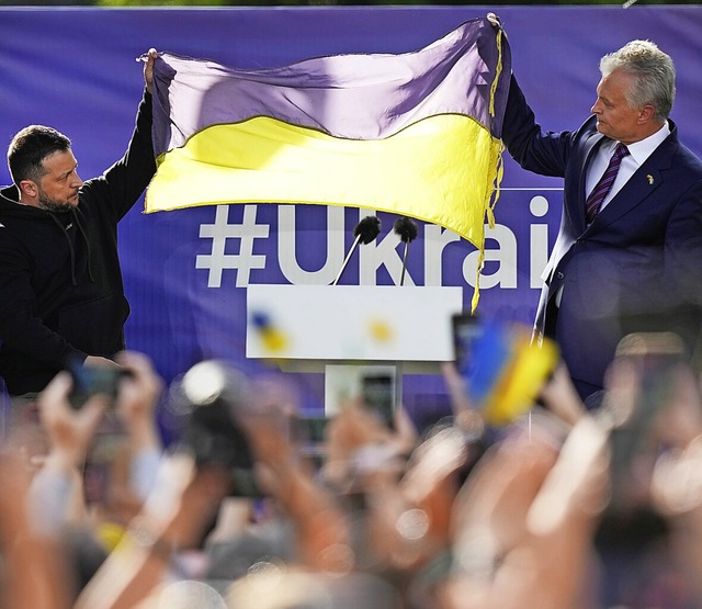 Wolodymyr Selenskyj (l.), Prsident de...in Vilnius die ukrainische Fahne hoch.  | Foto: Pavel Golovkin (dpa)