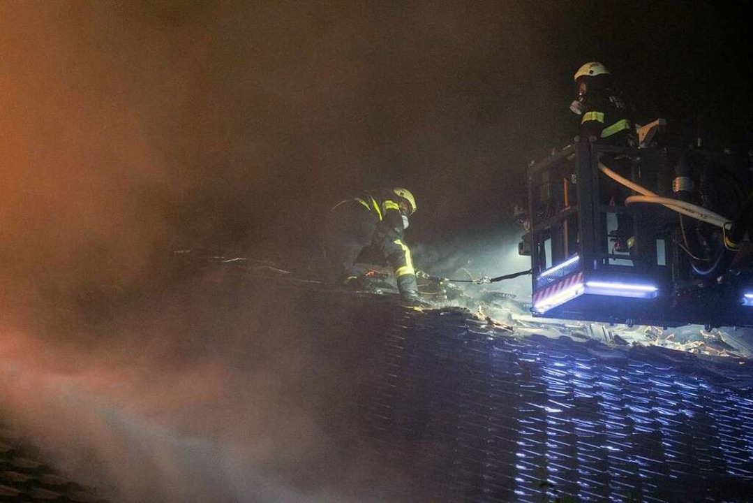 Feuerwehrleute kletterten gesichert an...n dem sie die Ziegelpfannen abräumten.  | Foto: Volker Münch
