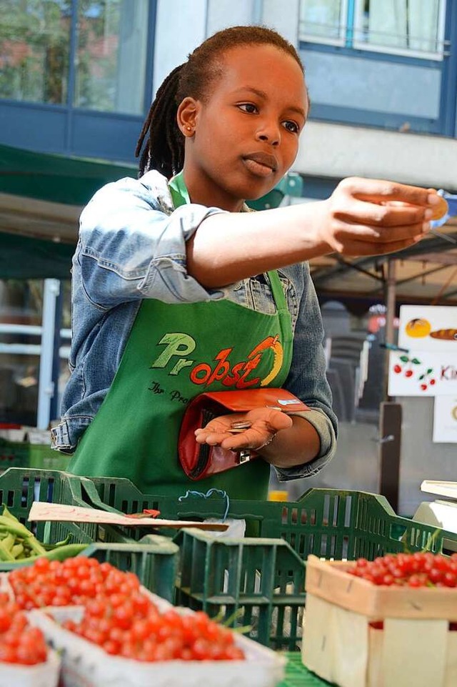 Auf dem Lrracher Wochenmarkt: Maria Chao wiegt, verpackt, kassiert, notiert.  | Foto: Moritz Lehmann