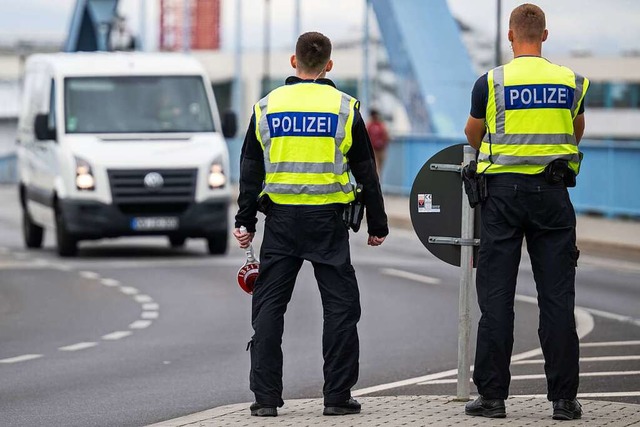Zwei Polizisten stehen an der deutsch-...polizei registriert als im Jahr zuvor.  | Foto: Hannes P Albert (dpa)