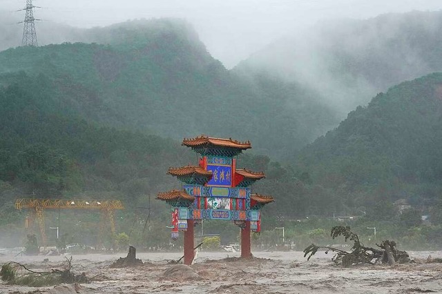 Endzeitstimmung in China: Ein Traditionelles Tor wird von Hochwasser umgeben.  | Foto: Ng Han Guan (dpa)