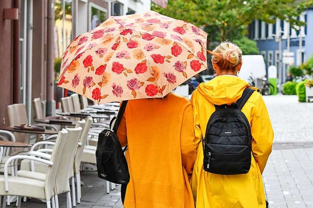 Zwei Frauen in Regenjacken laufen an d...nem Eiscaf in der Marktstrae vorbei.  | Foto: Endrik Baublies