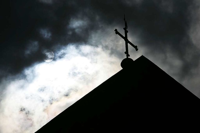 Dunkle Wolken ber der Katholischen Kirche (Symbolbild)  | Foto: Friso Gentsch (dpa)