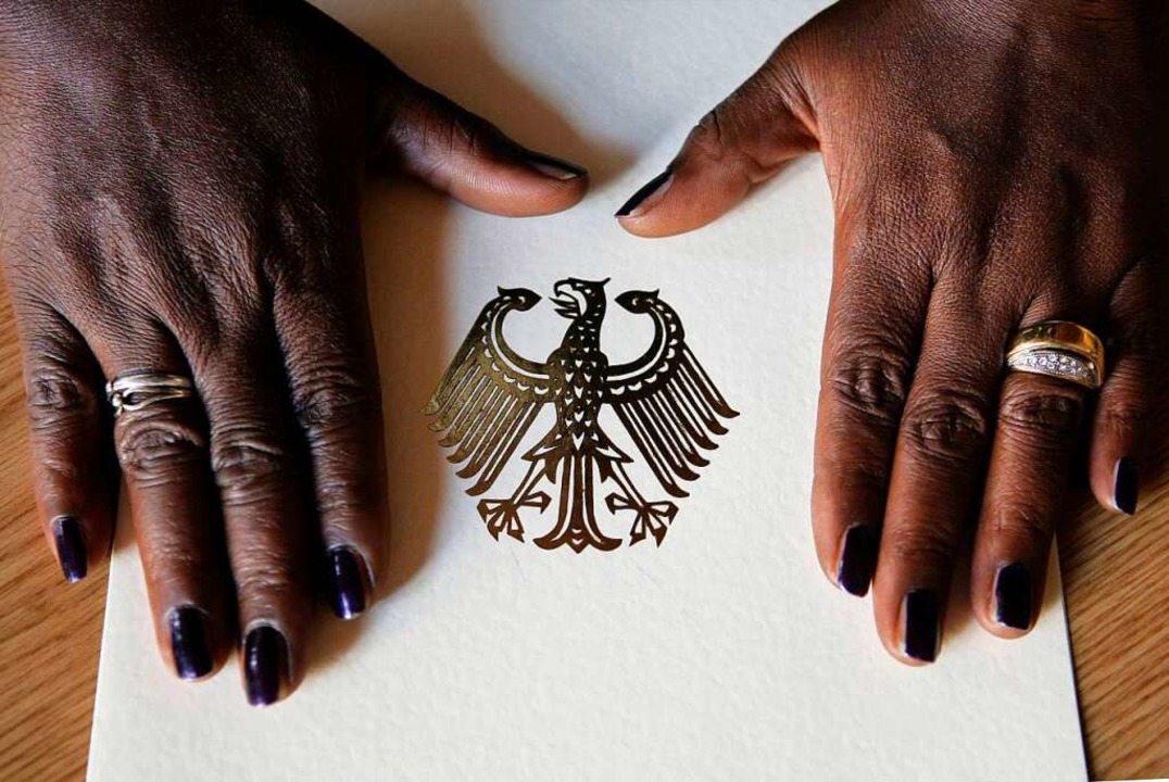 Die Hände einer Frau liegen auf der Ei...hung der deutschen Staatsbürgerschaft.  | Foto: Peer Grimm (dpa)