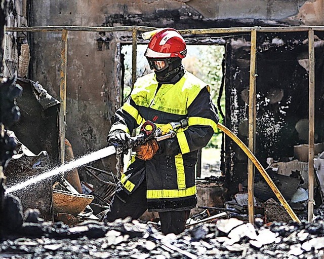 Lscharbeiten in einem ausgebrannten Haus in Saint-Andr.  | Foto: CHARLY TRIBALLEAU (AFP)