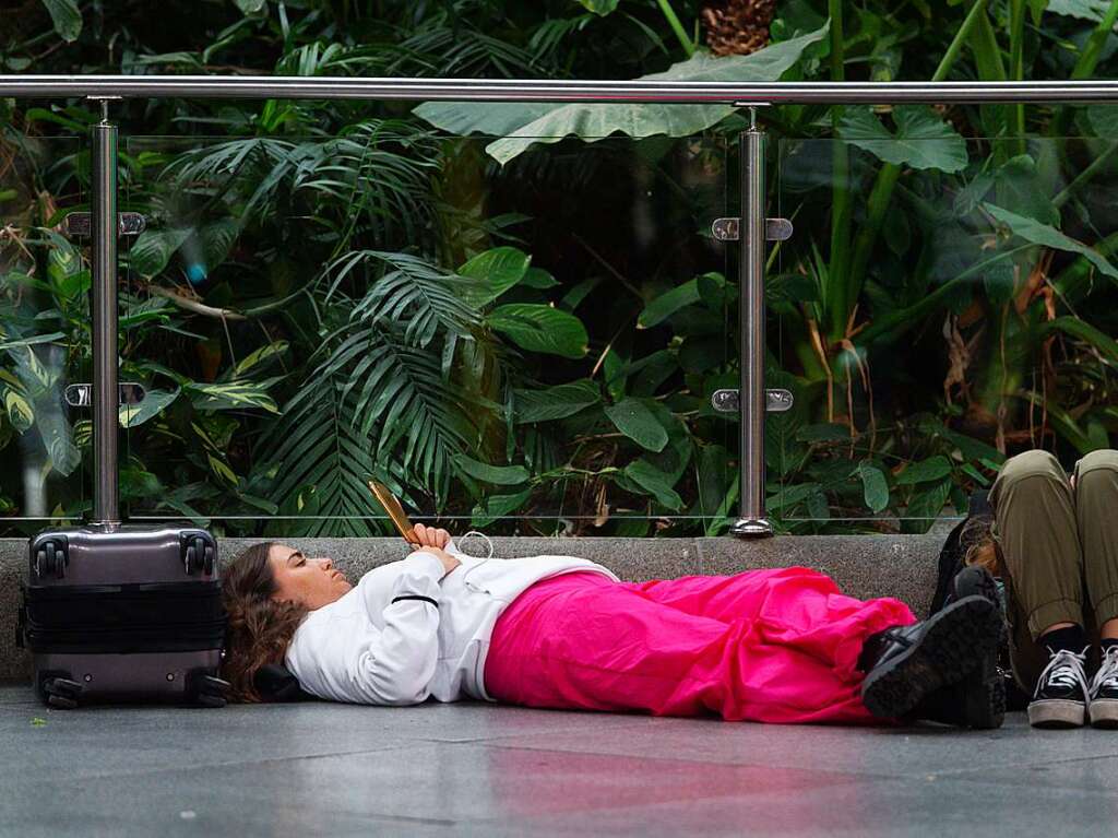 Reisende warten am Bahnhof Atocha-Almudena Grandes.