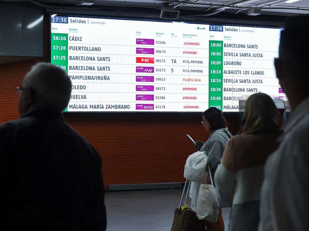 Mehrere Menschen mit ihren stornierten Reisen warten am Bahnhof Atocha-Almudena Grandes.