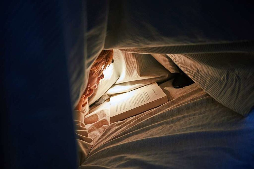 Lesen im dunkeln schadet den Augen. Das stimmt tatsächlich.  | Foto: Annette Riedl (dpa)