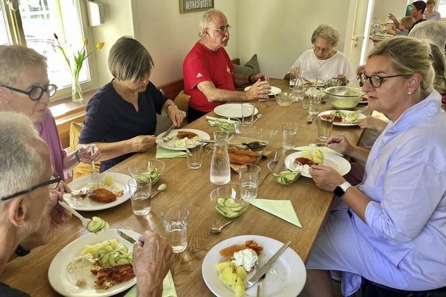 Alt und jung essen im Familienzentrum an einem Tisch
