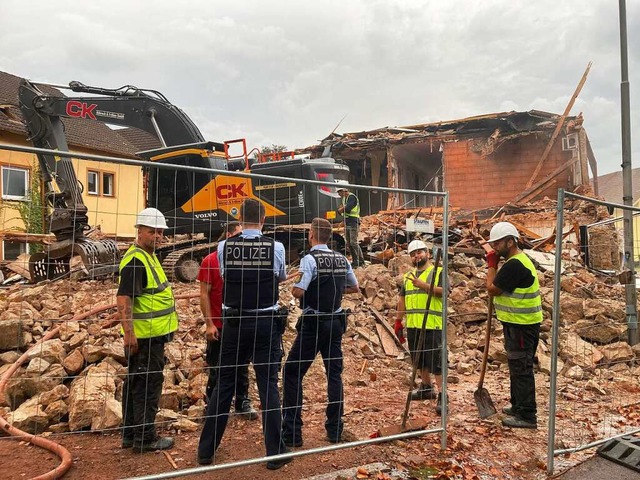 Polizisten halten die Arbeiter dazu an, die Abrissarbeiten einzustellen.  | Foto: Annemarie Rsch