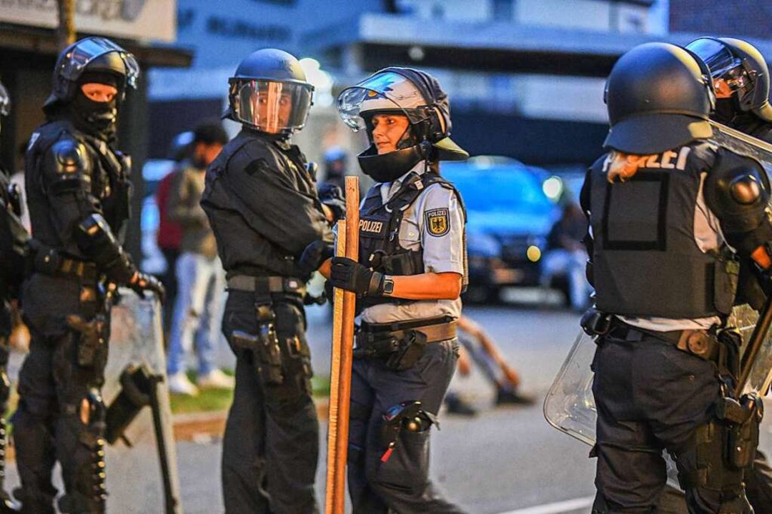 Eine Polizistin trgt nach Ausschreitu...Eritrea-Veranstaltung Holzstangen weg.  | Foto: Jason Tschepljakow (dpa)