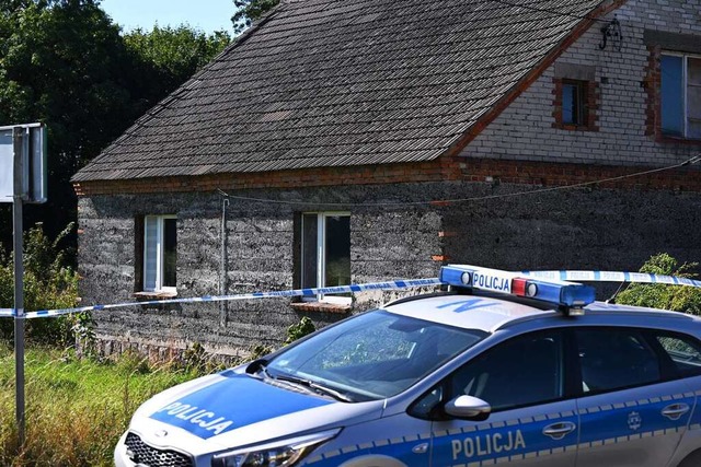 Ein Auto der Polizei steht whrend Erm...rene in einem heruntergekommenen Haus.  | Foto: Adam Warzawa (dpa)