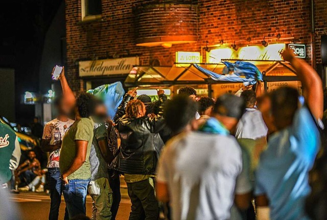 Eine Gruppe von Menschen feiert whren...von Polizeikrften eingekesselt ist. B  | Foto: Jason Tschepljakow (dpa)