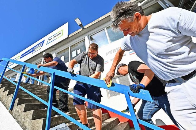 Malermeister Norbert Winterhalter und EHC-Fans schleifen das Treppengelnder ab.  | Foto: Michael Bamberger