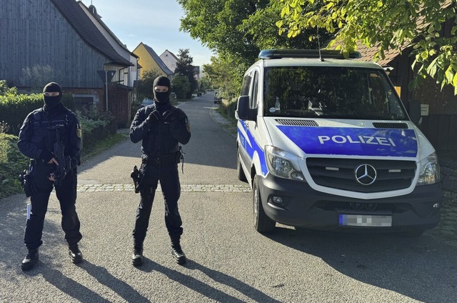 Polizisten sichern in Kupferzell eine Durchsuchung ab.   | Foto: Jan-Philipp Strobel