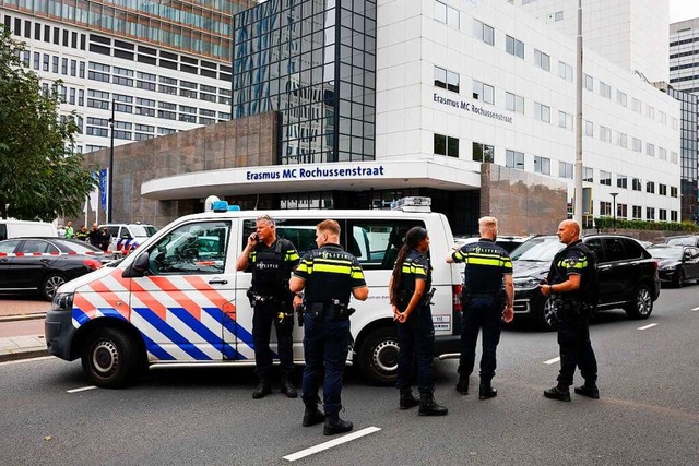 Polizeibeamte stehen vor dem Erasmus-K...n einer Wohnung und einem Krankenhaus.  | Foto: Bas Czerwinski (dpa)