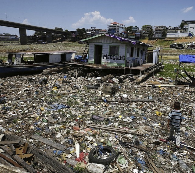 Ein Junge in Manaus vor einem eigentli...Haus, am ehemaligen Ufer eines Flusses  | Foto: Edmar Barros (dpa)