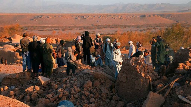 Menschen stehen nach einem Erdbeben in...Herat in den Trmmern von Wohnhusern.  | Foto: Mashal (dpa)