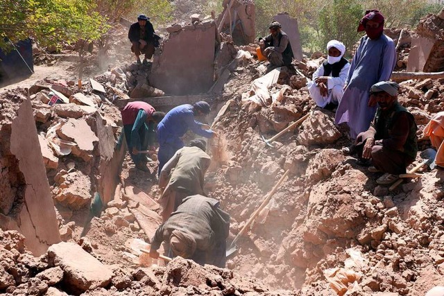 Afghanische Mnner suchen nach einem E...at im Westen Afghanistans nach Opfern.  | Foto: Benyamin Barez (dpa)