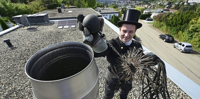 Schornsteinfegermeister Markus Banghar... einem Flachdach an einem Schornstein.  | Foto: Bernd Weibrod (dpa)