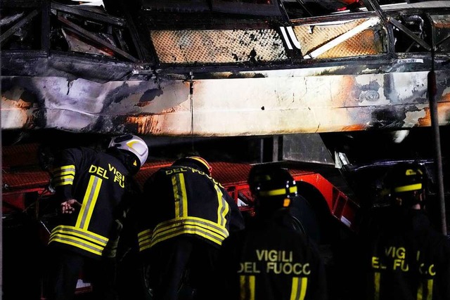 Italienische Feuerwehrleute arbeiten nach einem Busunglck an der Unfallstelle.  | Foto: Antonio Calanni (dpa)