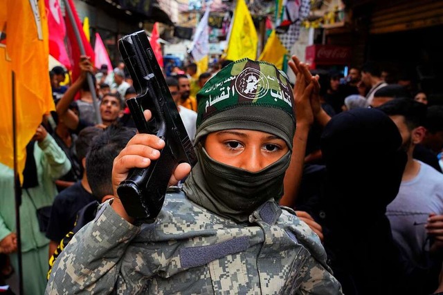 Ein palstinensischer Junge hlt eine ...griffe der Hamas auf Israel zu feiern.  | Foto: Bilal Hussein (dpa)