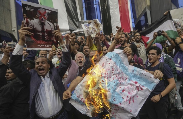 gyptische Demonstranten verbrennen in Kairo eine israelische Nationalflagge.  | Foto: Amr Nabil (dpa)