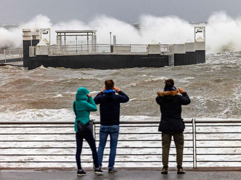 Besucher des Hafens in Kiel-Schilksee fotografieren die ber die Hafenanlagen niedergehenden Wellen.