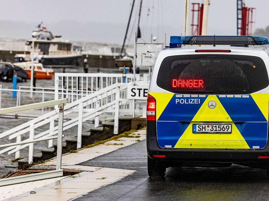 Ein Polizeifahrzeug warnt Passanten an den Hafenanlagen in Schilksee.