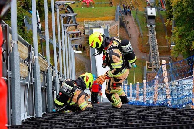 Feuerwehrleute spurten Treppen der Skiflugschanze in Oberstdorf hoch