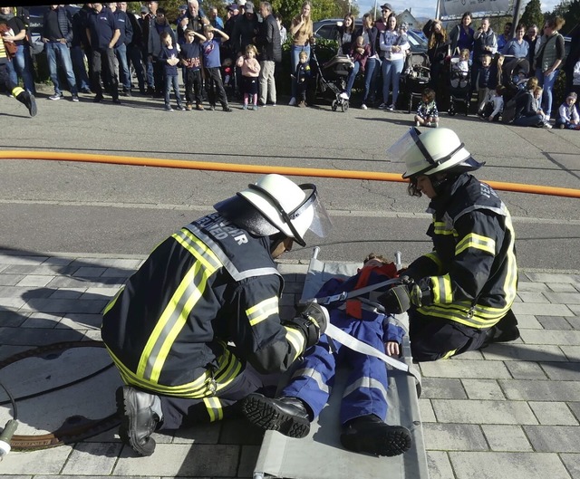 Whrend die Feuerwehrleute krftig anp...uerinnen und Zuschauer das Geschehen.   | Foto: Hans Spengler