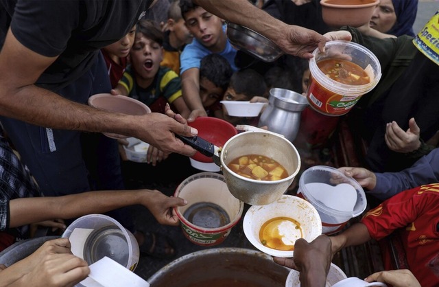 Palstinensische Kinder im Gazastreifen erhalten  Essen in einer Schule.  | Foto: MOHAMMED ABED (AFP)