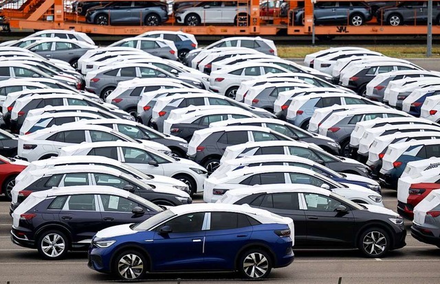 Fertige, vollelektrische Fahrzeuge aus...au stehen auf einem Parkplatz im Werk.  | Foto: Hendrik Schmidt (dpa)