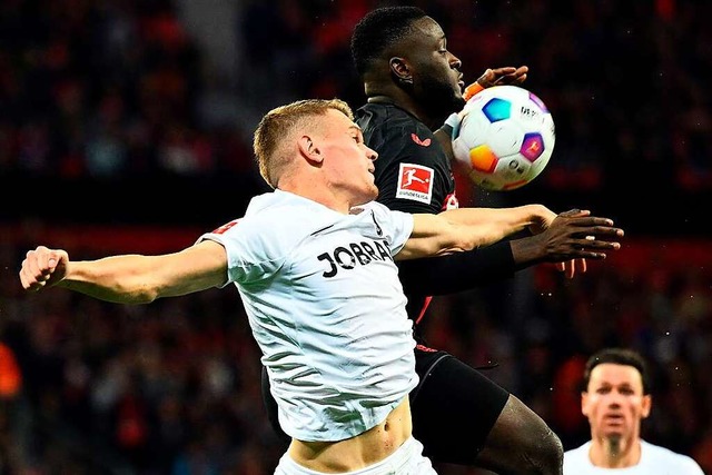 Matthias Ginter vom SC Freiburg (links...ll mit Bayer-Angreifer Victor Boniface  | Foto: INA FASSBENDER (AFP)