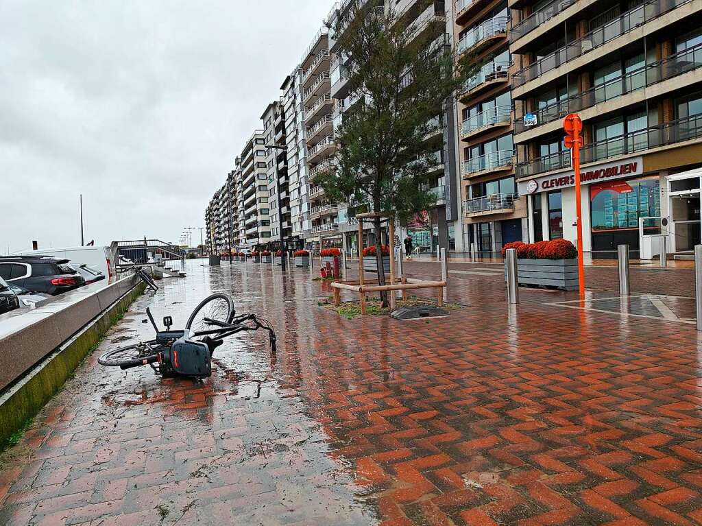 Belgien, Blankenberge: Ein Fahrrad liegt vom Wind umgeweht auf einer Deichpromenade.