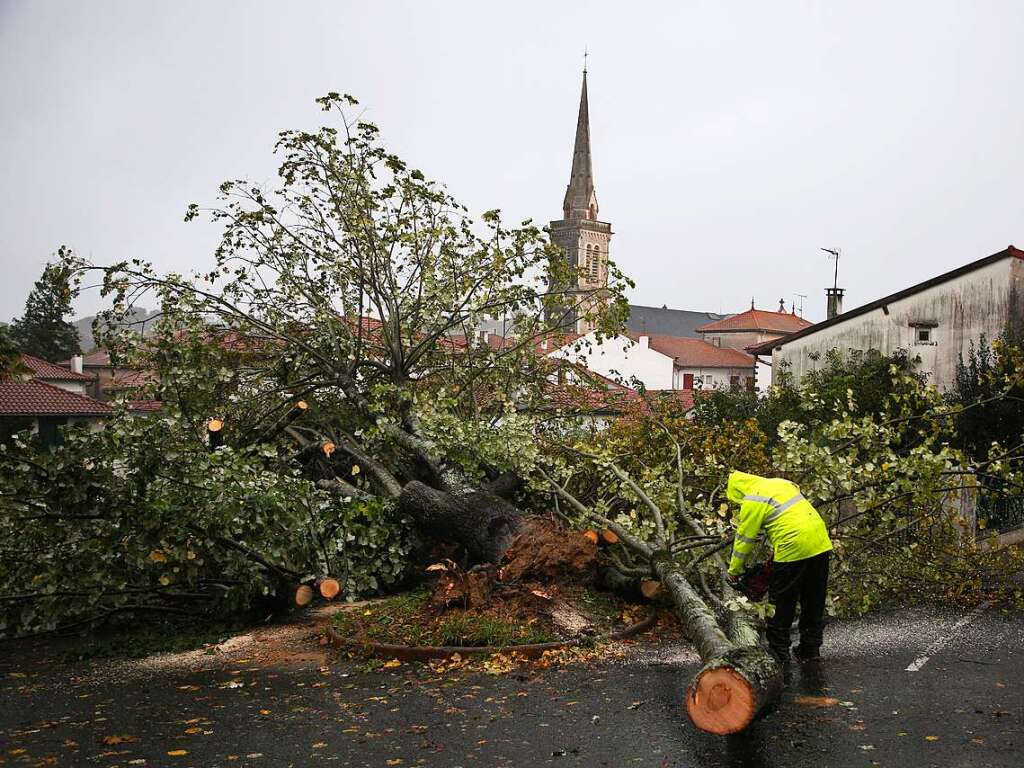 Frankreich, Hasparren: Ein Mann zersgt einen Baum, der auf einen Parkplatz gestrzt ist.