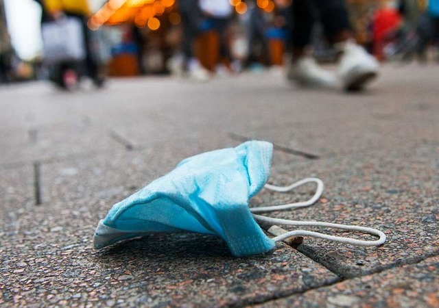 Eine Maske liegt auf dem Boden: Vor dem Landgericht Freiburg  | Foto: Daniel Bockwoldt (dpa)