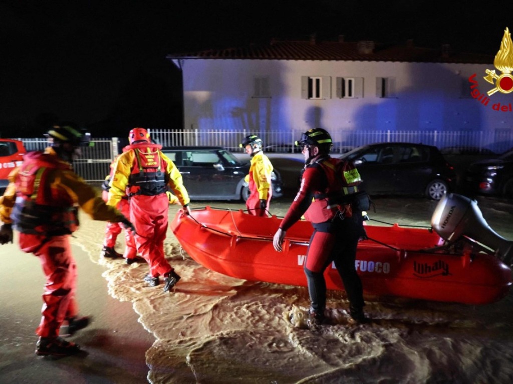 Feuerwehrmnner evakuieren Leute aus berschwemmten Husern in der Nhe von Florenz.